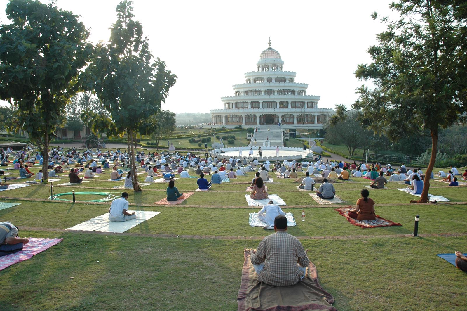 Yoga vor Meditationshalle im Art of Living-Ashram in Indien