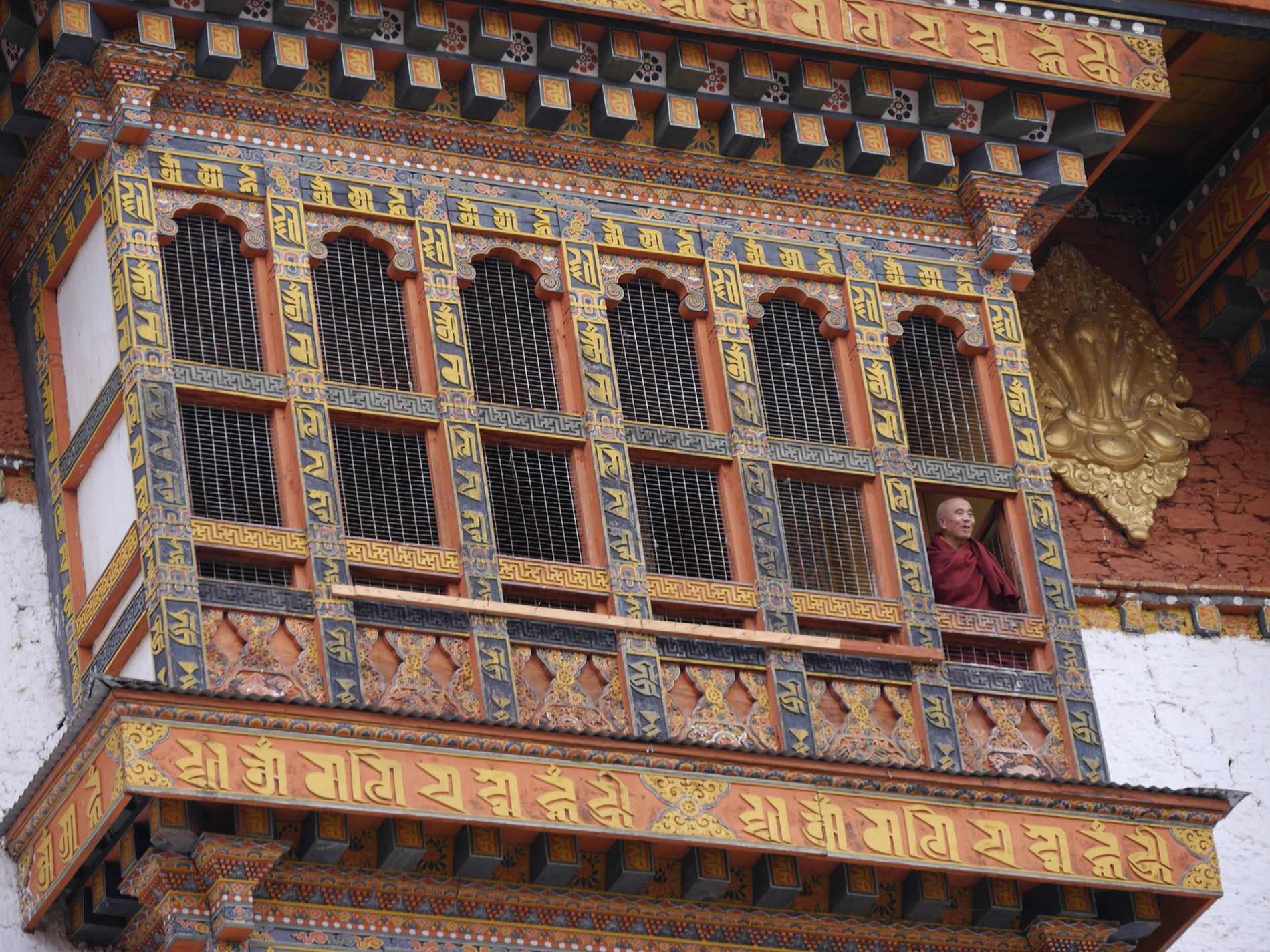 Lachender Mönch im Fenster eines Klosters in Dzong Punakha
