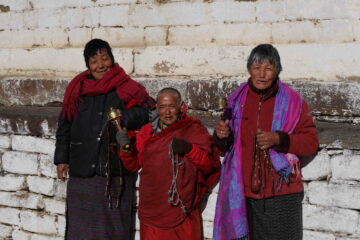 Bhutanerinnen mit Gebetstrommeln vor dem Kloster