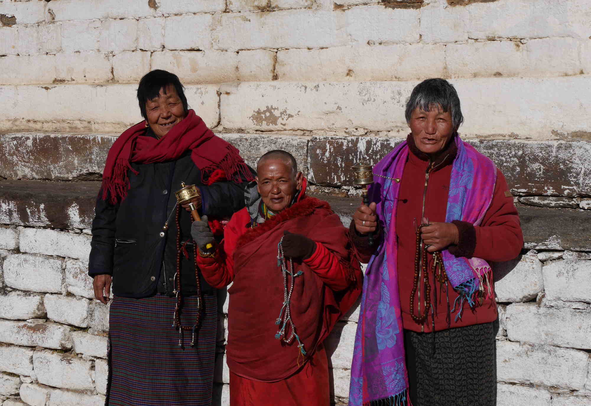 Bhutanerinnen mit Gebetstrommeln vor dem Kloster