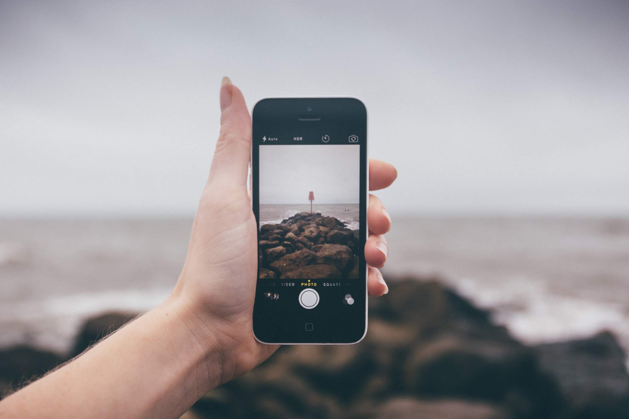 Blick aufs Handy mit Bild vom Strand