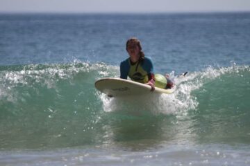 Frau mit Surfboard auf dem Wasser