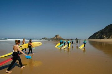 Gruppe mit Surfboard am Strand