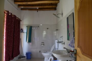 Badezimmer mit Waschbecken, WC und Dusche in Gästehaus in Ladakh