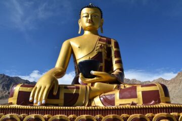 Goldene Buddha-Statue vor blauem Himmel