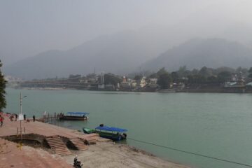 Ganges mit Booten und Hügel im Hintergrund