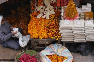 Dunkelgelbe Blüten und Ketten als einem Marktstand in Nordindien