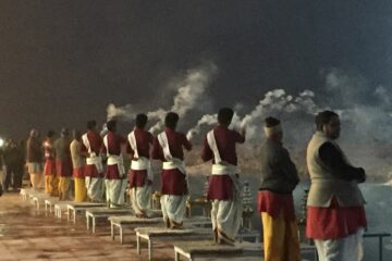 Männer räuchern in Richtung des Ganges beim Abendaarti in Rishikesh