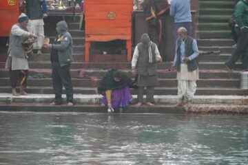 Frau schöpft Wasser aus dem Ganges