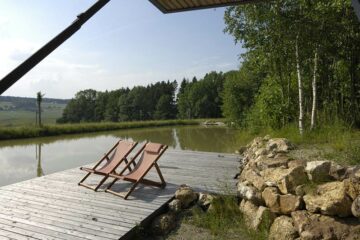 Zwei Liegestühle am Steg direkt am Wasser