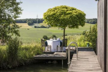 Einsamer Tisch für zwei auf Steg im Grünen