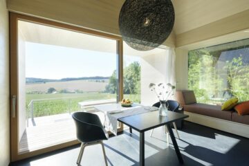 Tisch und Sofa vor Fenster auf Terrasse