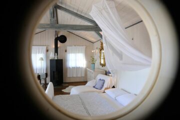Blick durch Bullaugenfenster auf Schlafzimmer