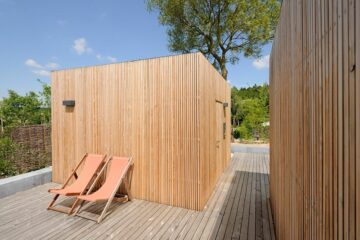 Holzsauna mit Liegestühlen