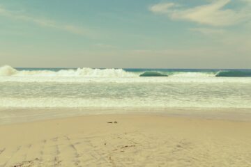 Strand und türkisblaue Wellen