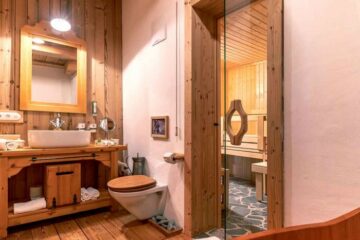 Badezimmer mit Dusche und angrenzender Sauna
