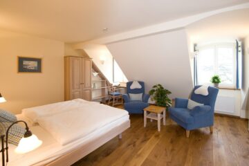Zimmer mit Doppelbett und blauen Sesseln