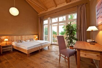 Zimmer in hellem Holz, Doppelbett und Balkon