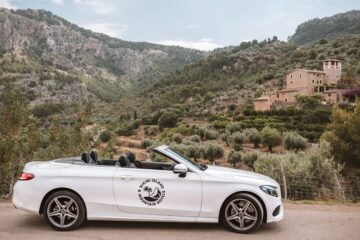 weißes Cabrio mit mallorcinischer Landschaft