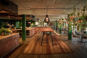 Raum mit Buffet, langer Tafel und vielen Pflanztöpfen die von der Decke hängen