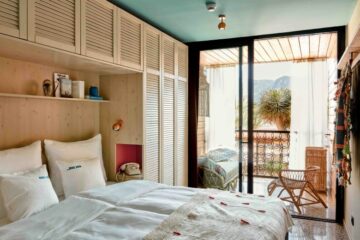 Zimmer mit Balkon und weißer Holzfront