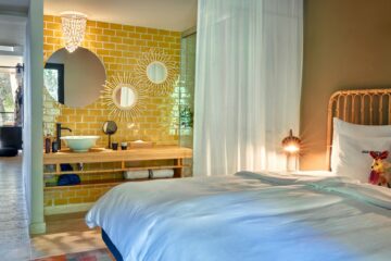 Bett mit gelb-gefliester Waschecke und Zugang zum Wohnraum und Terrasse