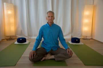 Trainer in meditativer Haltung auf Matte