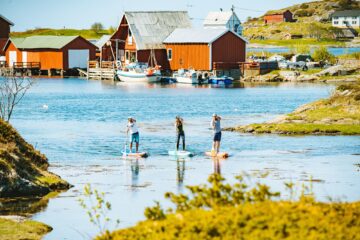 Drei Personen auf SUP im Fjord