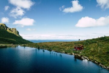 Fjord und tiefblaues Wasser und rote Hütte