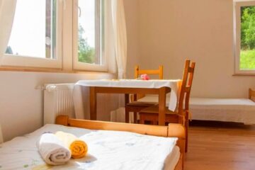 Zweibett-Zimmer im Meditationszentrum mit Tisch und Stühlen