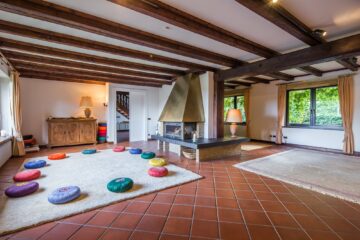 Raum mit Teppich und Yogakissen und Kamin in der Mitte