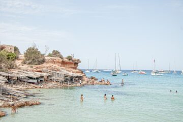 Bucht mit Badegästen und Segelbooten