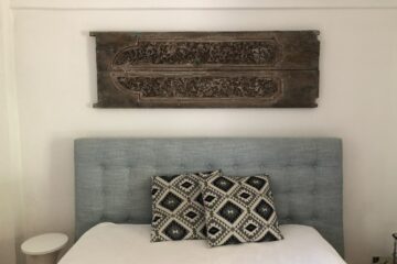 Kissen auf Bett und Holzdekor an Wand