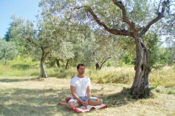 Yogalehrer Christoph meditiert unter Olivenbaum