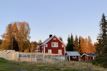 Rotes Haus mit kleinen Hütten