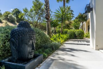 Großer Buddhakopf mit Wasser im Garten