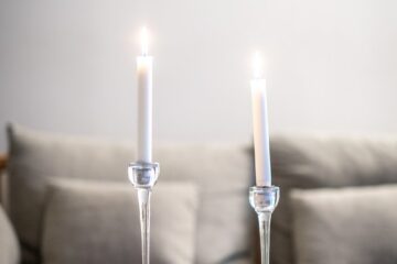 Zwei weiße Kerzen auf Tisch