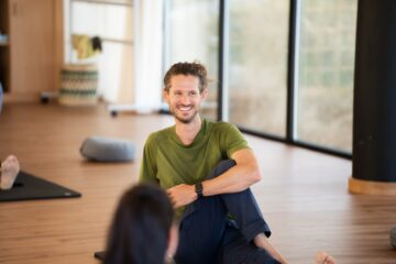 Mann lächelt bei Yoga-Übung
