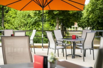 Terrasse mit grauen Tischen und Stühlen