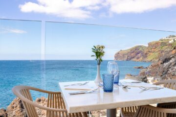 Gedeckter Tisch an Glasfront die zum Meer ausgerichtet ist