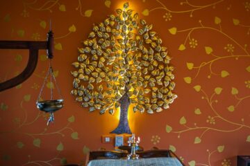 Baum mit goldenen Blättern an der Wand und Tapete mit goldranken