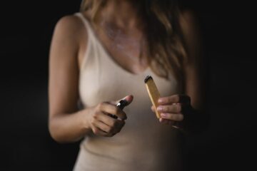 Frau mit Feuerzeug und Palo Santo Holz