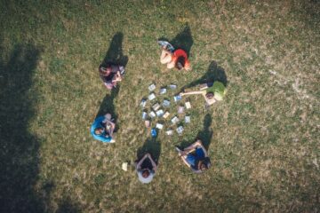 Gruppe sitzt um Kreis aus Karten zusammen auf dem Boden