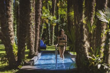 Frau im Kneipp-Wasserbecken zwichen Palmen