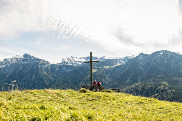 Gipfelkreuz mit zwei Radlern