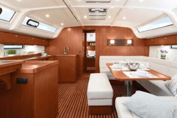Salon im Segelboot mit Küche, Sofa und Tisch