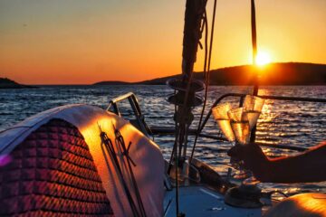 Gläser mit Sekt bei Sonnenuntergang auf dem Boot
