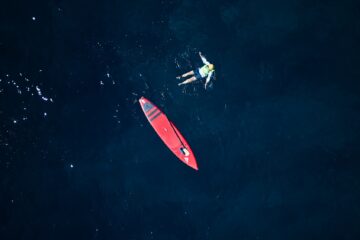Badender neben SUP im Meer
