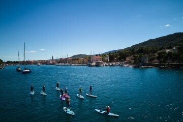 SUP-Gruppe entlang stadt