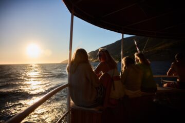 Gruppe an der Reling bei Sonnenuntergang